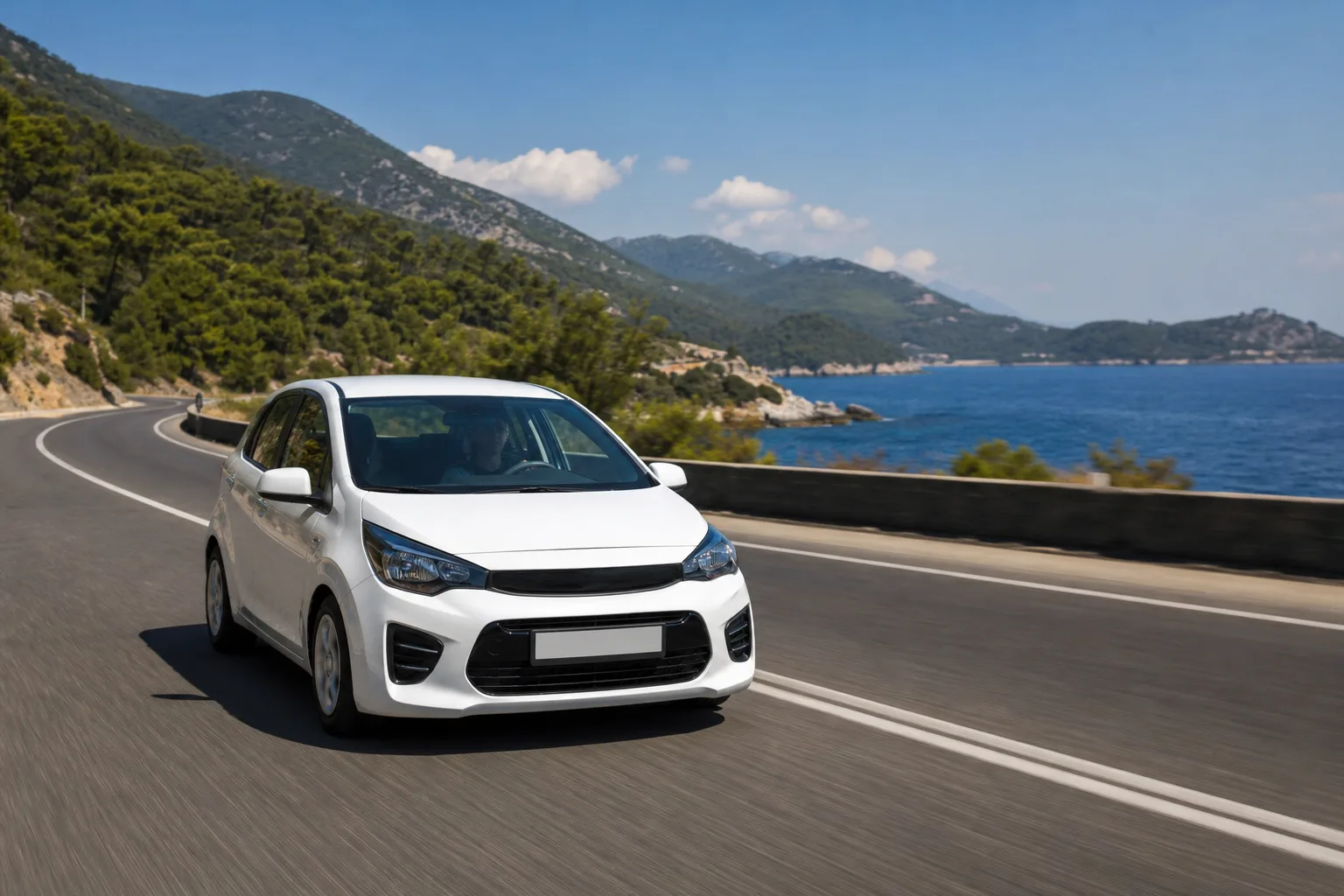 A white compact rental car on a coastal Turkish highway, with the Mediterranean and pine hills alongside.