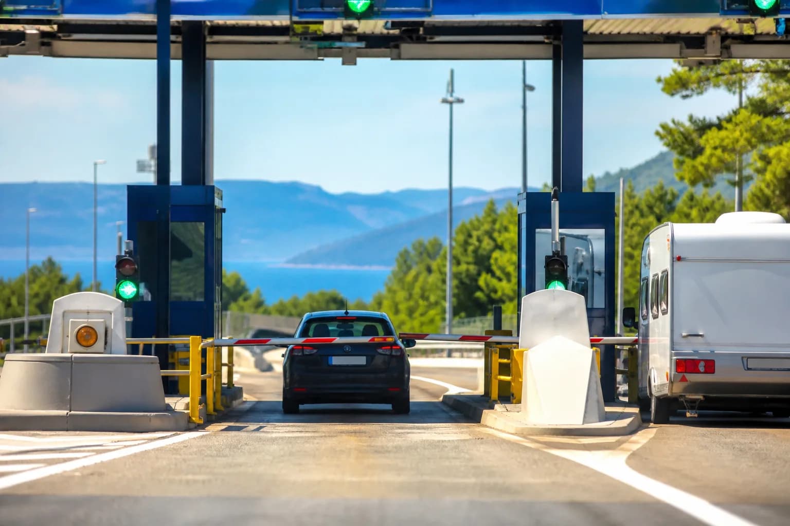 Mautstelle an einer kroatischen Küstenautobahn, daneben ein Wohnwagengespann.
