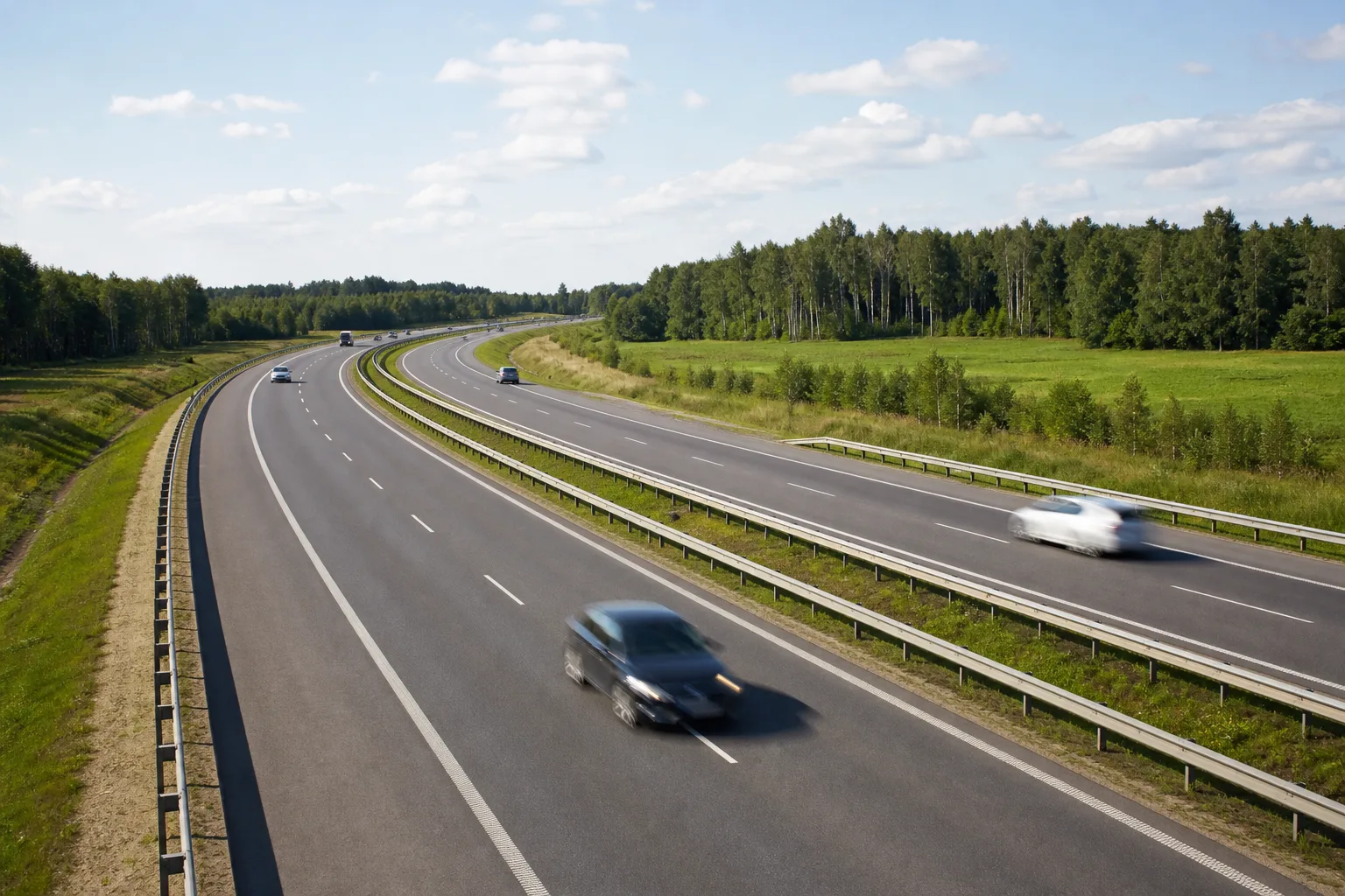 A modern Polish motorway through flat green countryside and birch woodland, evoking Poland's high motorway speed limits.